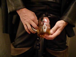 Rubber pig is pissing in a glass