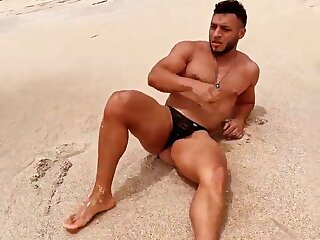 Hot bodybuilder is showing off at the beach wearing a tiny thong