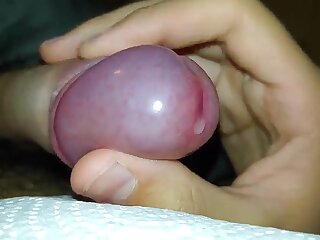 Teen stimulates his uncut dick by massaging his frenulum under the covers