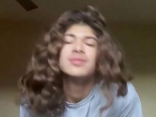 A long haired twink stripping