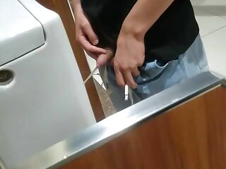 A male is pissing in the toilet 3.